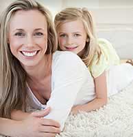 woman and child laying on carpeting