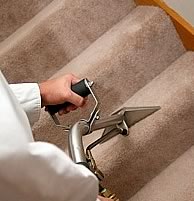 man steam cleaning carpeting